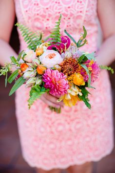 a woman in a pink dress holding a bouquet of flowers