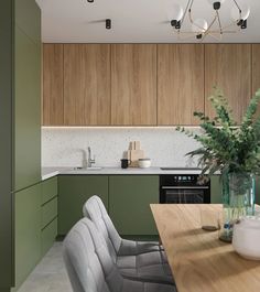 a kitchen with green cabinets and white counter tops is seen in this image from the dining room table