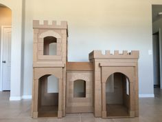 three cardboard castles are stacked on top of each other in the middle of a room