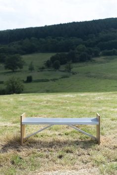 a bench sitting on top of a grass covered field