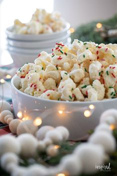 a white bowl filled with popcorn and sprinkles on top of a table