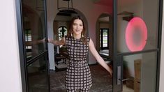 a woman standing in front of a glass door with her hands out and arms outstretched