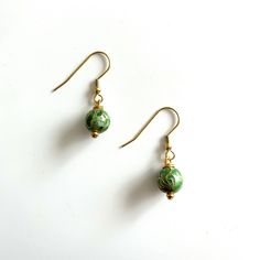 Green Cloissone earrings. 10mm. These earrings dangle from gold plated ear wires Elegant Beaded Drop Earrings With French Hook, Elegant Beaded Earrings With French Hook As Gift, Gold Round Beads Flower Earrings As Gift, Gold Flower Earrings With Round Beads For Gift, Everyday Green Lever Back Earrings, Gold Beaded Dangle Earrings With French Hook, Gold Jewelry With French Hook And Round Beads, Gold Beaded Earrings With French Hook As Gift, Everyday Gold Round Bead Earrings