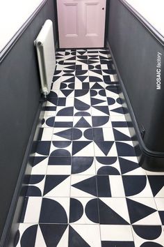 a black and white tiled floor with a pink door in the corner, next to a radiator