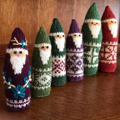 knitted christmas decorations are lined up on a table