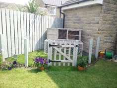 an outdoor area with a fence, potted plants and flowers