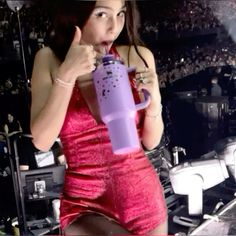 a woman in a red dress holding a purple cup