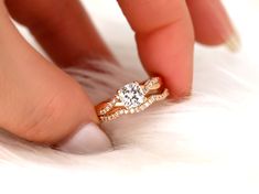 a woman's hand with a diamond ring on top of her finger and white fur