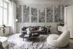 a living room filled with furniture and walls covered in wallpaper