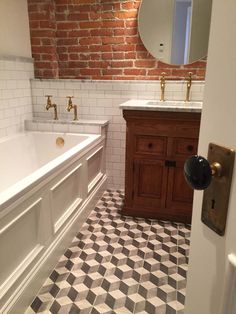 a bathroom with two sinks and a bathtub next to a mirror on the wall