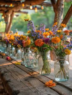 several vases filled with colorful flowers sitting on top of a wooden table