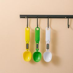 three measuring spoons are hanging on the wall