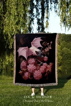 a bat hanging from the side of a tree in front of a field with grapes