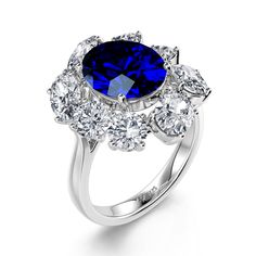 a blue and white diamond ring with three stones on the side, surrounded by diamonds