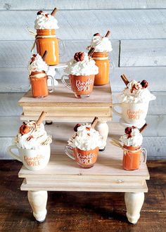 an assortment of desserts are arranged on a small table with cups and spoons