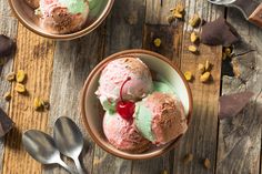 two bowls filled with ice cream on top of a wooden table