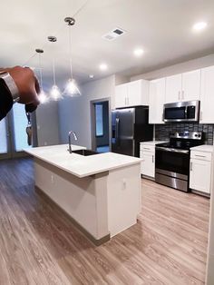 a kitchen with white cabinets and black appliances