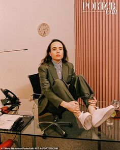 a woman sitting in an office chair with her feet on the desk