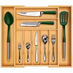 an open drawer with various kitchen utensils and knives in it on a white background