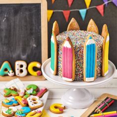 a birthday cake decorated with colorful icing and sprinkles on a table