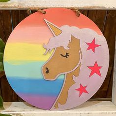 a wooden sign with a unicorn on it's face and stars in the background