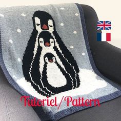 a blanket with two penguins on it sitting on a couch