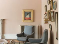 a living room filled with furniture and pictures on the wall next to a radiator