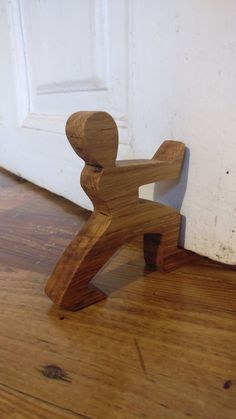 a wooden toy sitting on top of a hard wood floor next to a white door