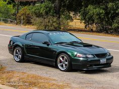 a green sports car parked on the side of the road