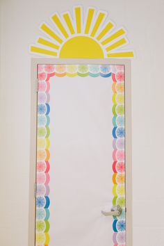 a white wall with a colorful frame and sun on it