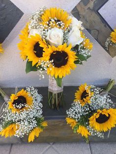 sunflowers and baby's breath are arranged in a bouquet on the ground