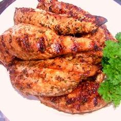 grilled chicken with parsley on a white plate