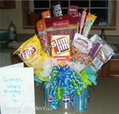 a birthday gift basket with candy, chips and candies on the counter next to a note