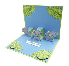 an elephant pop up card with three elephants on it's side and the word happy new year written below