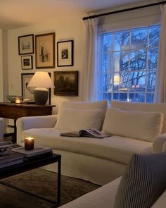 a living room filled with white furniture next to a window