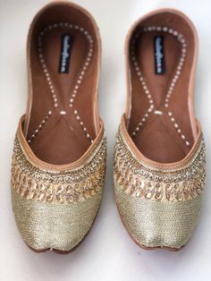 Timeless beauty is 'GRACEFUL GOLD' to be clubbed with any outfit to get the stunning glaze. This jutti with gold embroidery and beads is a contemporary classic pair of juttis which is a perfect accompaniment to just about anything. *Ethnic Shoes/Women Flats/Handmade Indian Designer Women Shoes or Slippers/Royal shoes/traditional style Women SPECIFICATIONS: *Upper/Panna - Gold fabric with embroidery, rhinestones and beads *Back/Adda - Gold fabric with embroidery, rhinestones and beads *Lining - L Bollywood Style Flats For Diwali Festive Season, Bollywood Style Flats For Diwali Festival, Festive Bollywood Flats With Gota Work, Bollywood Style Festive Flats With Gota Work, Bollywood Style Festive Flats With Mirror Work, Bollywood Style Flats With Mirror Work For Festive Occasions, Festive Diwali Flats With Mirror Work, Festive Flats With Dori Work, Festive Ankle-length Flats With Dori Work