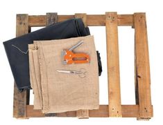 a pair of scissors and some fabric sitting on a wooden frame with other items in it