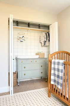 a baby's room with a crib, dresser and changing table in it