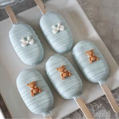 four blue desserts with white and brown decorations on them are sitting on a plate