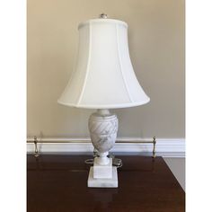 a white lamp sitting on top of a wooden table