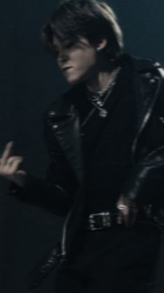 a man in black leather jacket holding his hand out