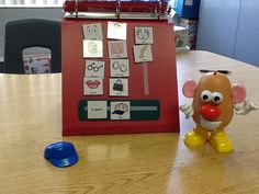 a table with a toy mouse next to a red clipboard on top of it