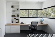 an office with a desk, chair and bookshelf in the corner near a window