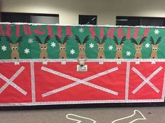 an office cubicle decorated for christmas with reindeers on the door and red barn doors