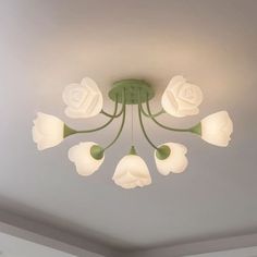 a chandelier with white flowers hanging from the ceiling