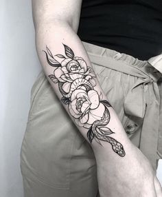 a black and white flower tattoo on the arm