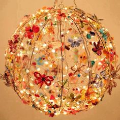 a colorful light fixture hanging from the ceiling with butterflies on it's wire and lights