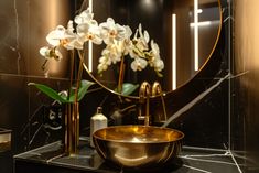 a bathroom with a sink, mirror and flowers in the bowl on the counter top