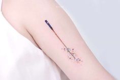 a woman's arm with a small tattoo on it and a pen in the middle