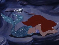 ariel from the little mermaid is laying on her stomach and looking at something in the water